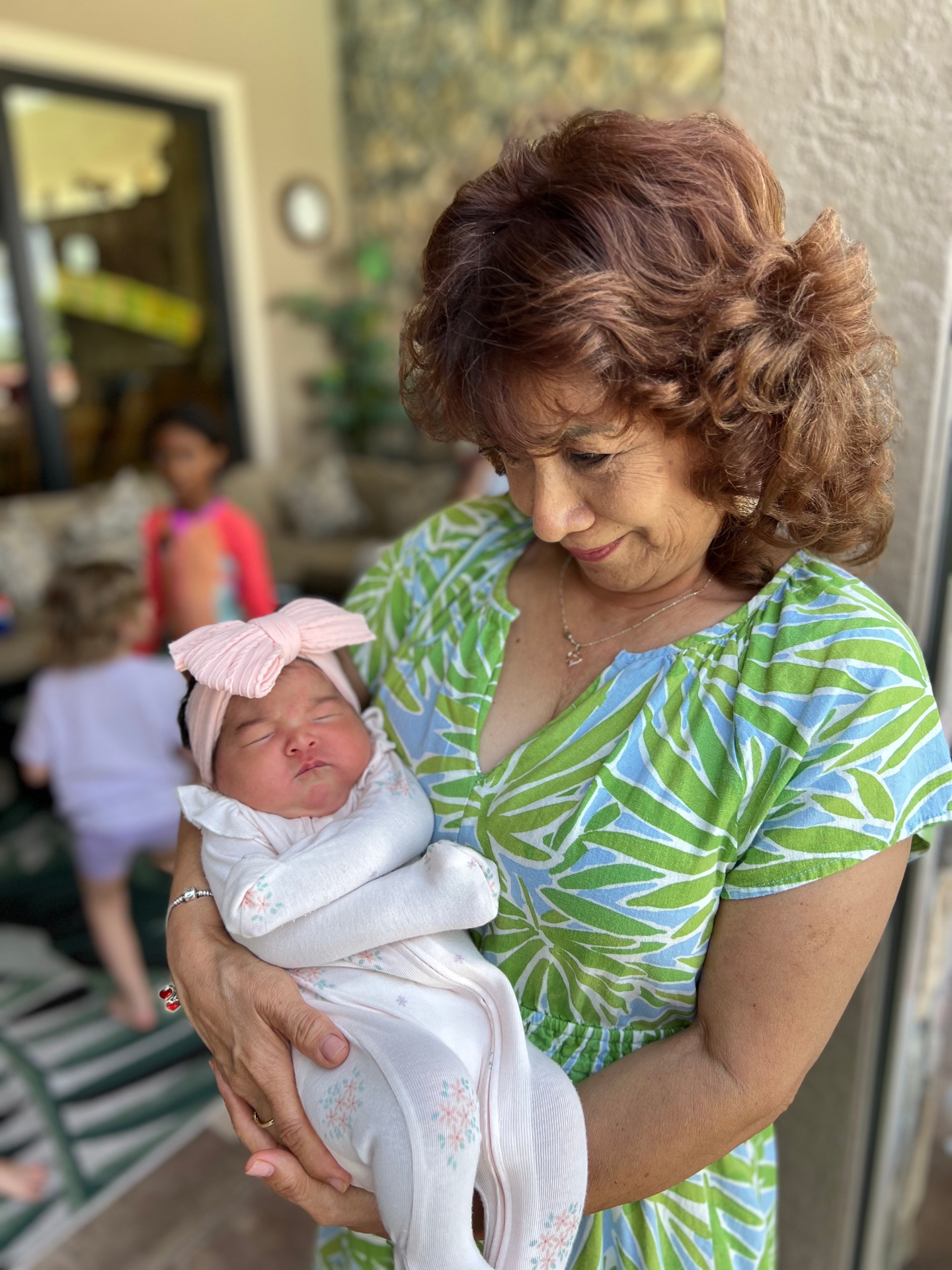 Flor Ayllon holding a newborn infant, establishing elite private childcare standards